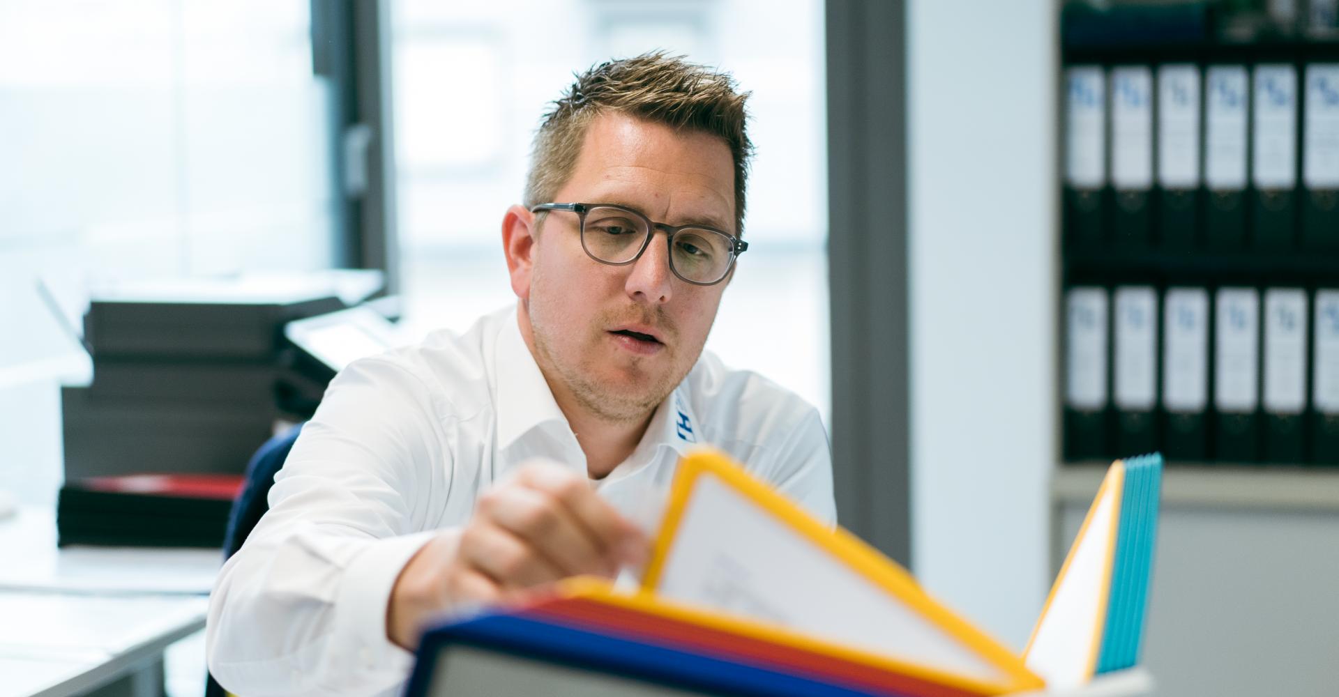 Fachkraft blättert in Unterlagen zu Verlegemuster
