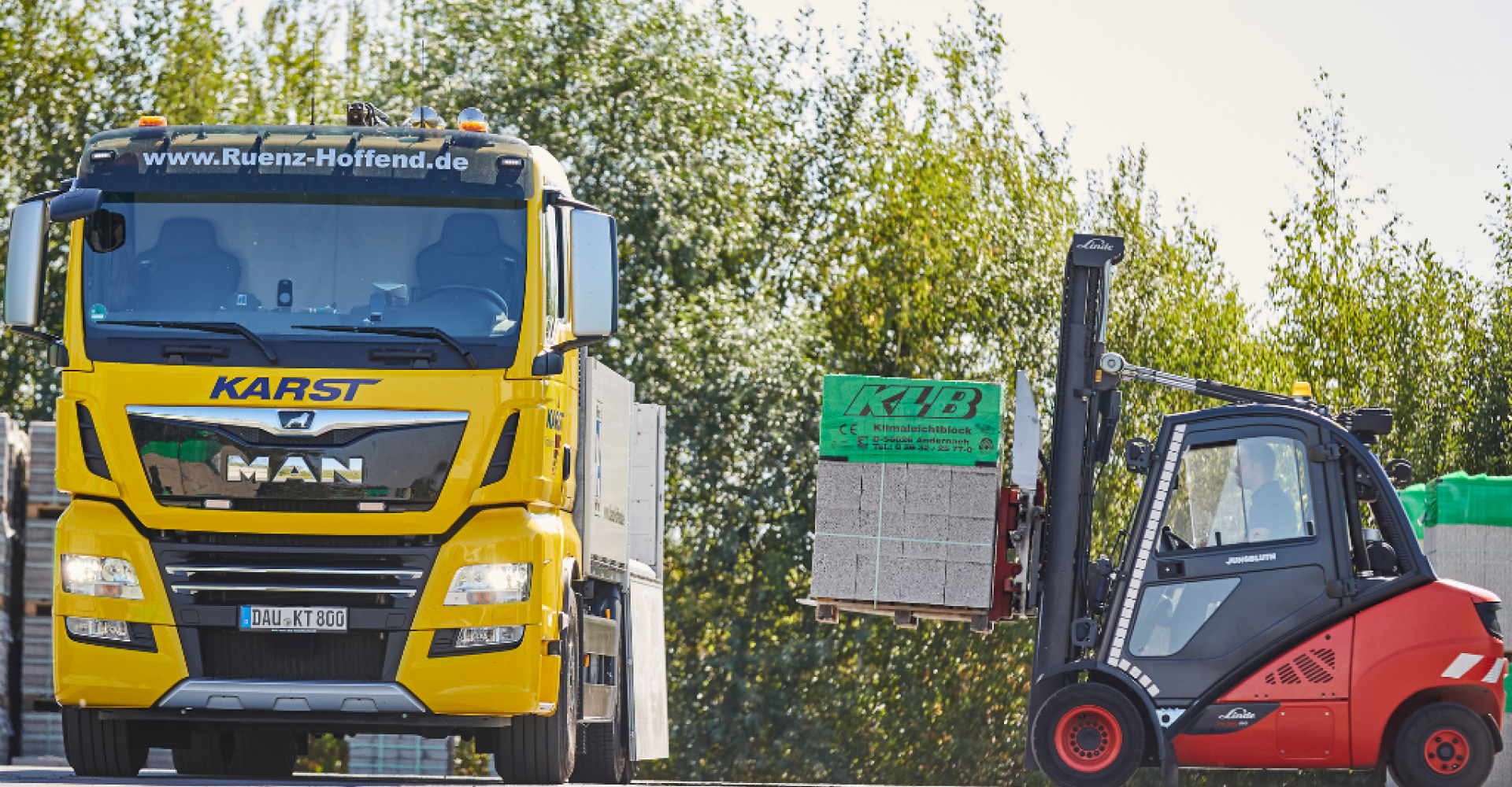 LKW der von Gabelstapler mit Palette mit Steinen beladen wird